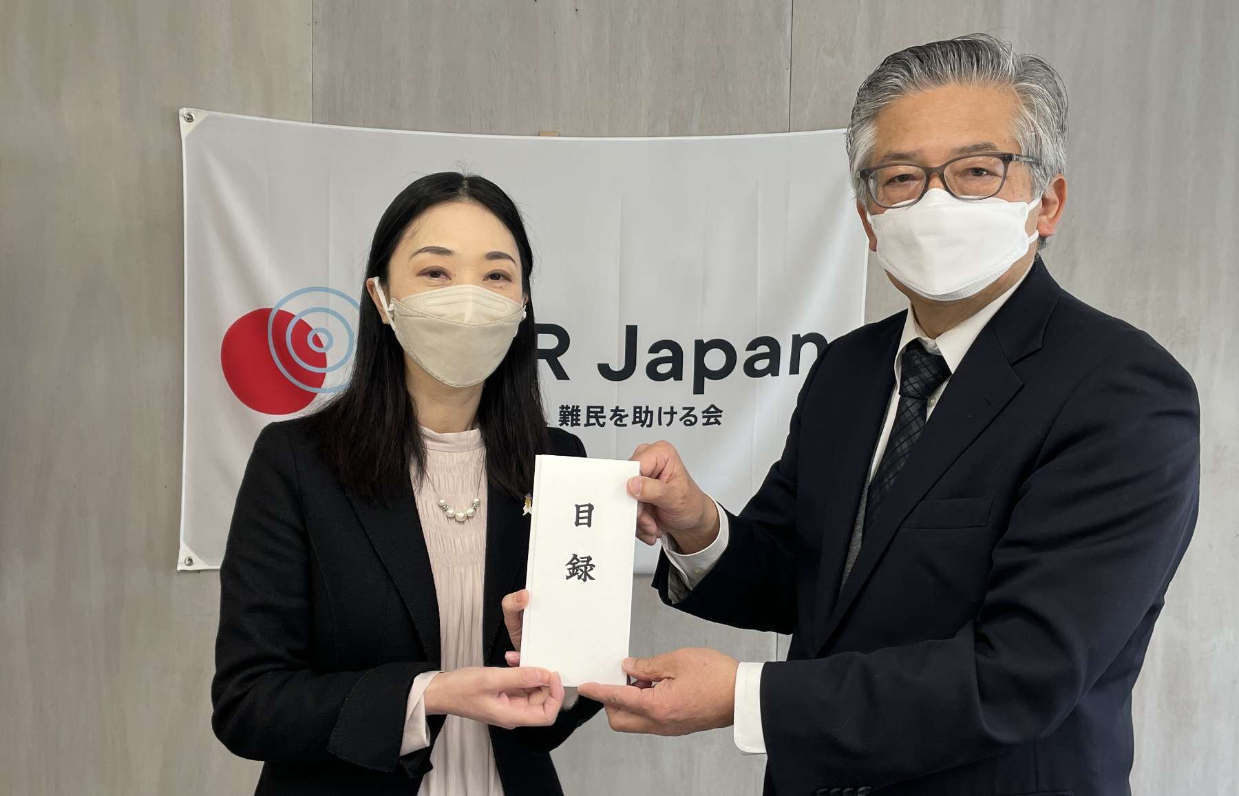 A donation list is handed over to Yuki Yoshizawa, acting secretary general (left in the photo), by a representative of Shinnyo-en.