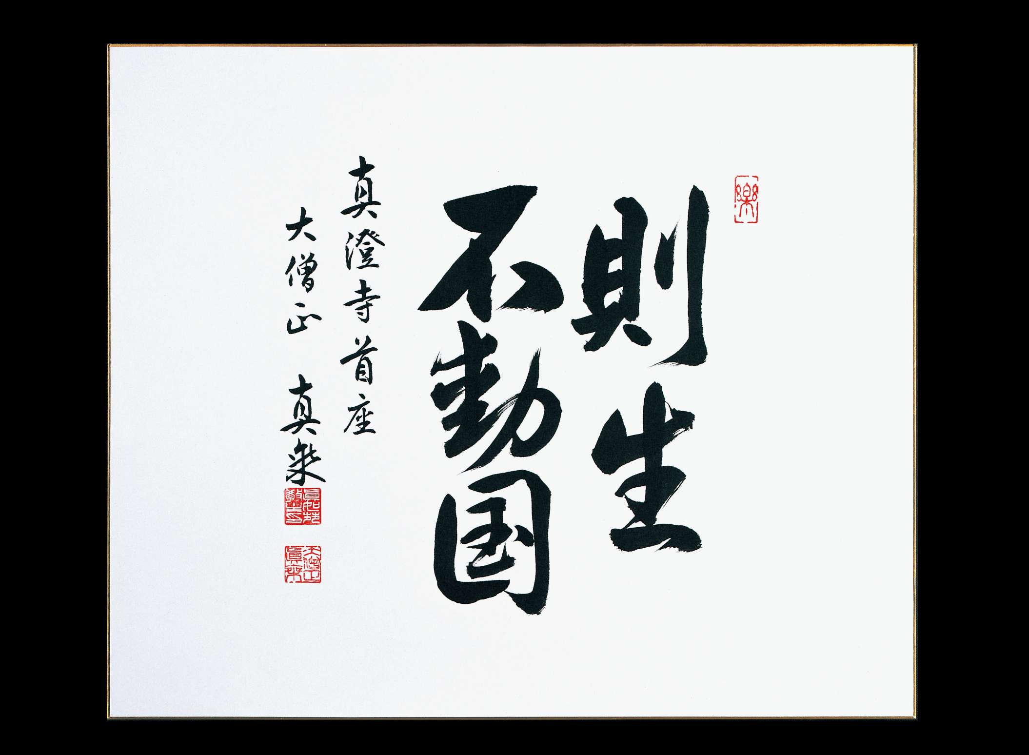Five large Japanese calligraphy characters are written with brush on a squat, rectangular sheet of paper; to the left are two smaller lines of calligraphy with two stamp impressions in red.
