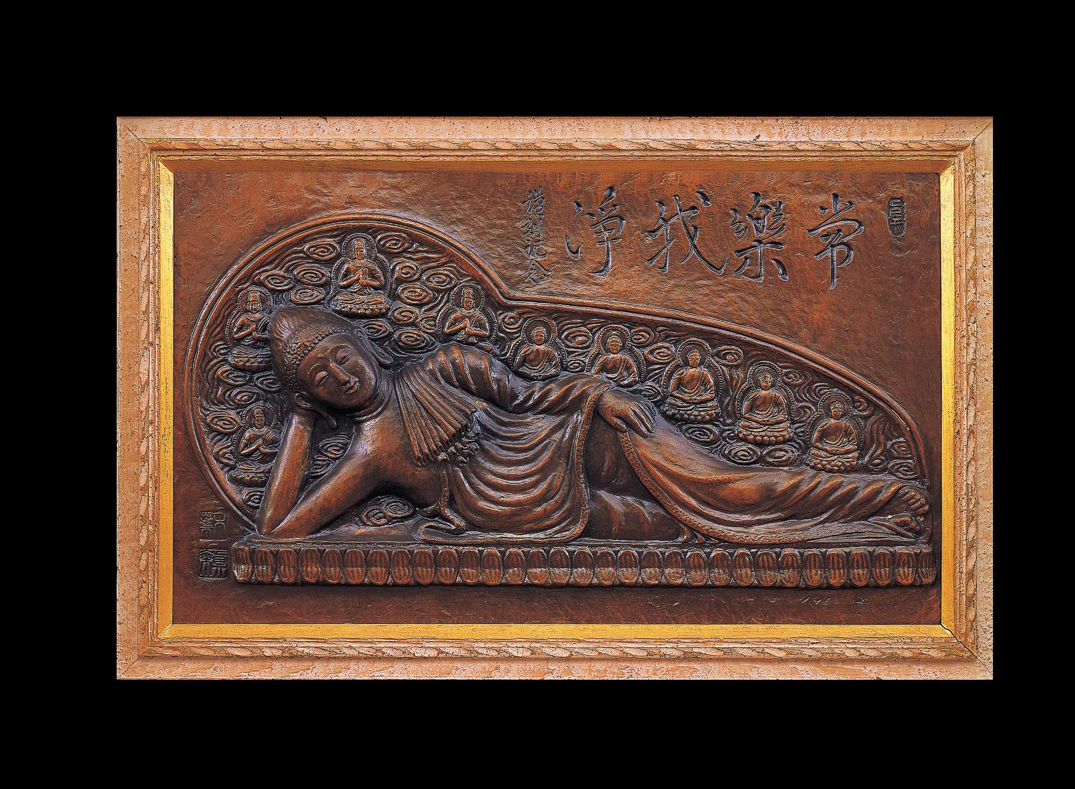 A relief of Buddha laying on his right side atop a bed of stylized lotuses, backed by a nimbus bearing 9 small buddhas is carved into a reddish brown slab near an etching of Japanese calligraphy.